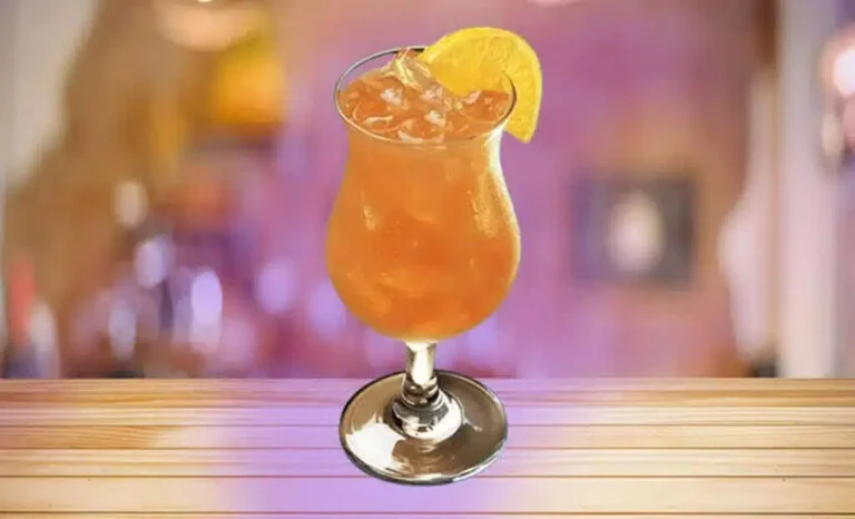 Close up of a Texas Roadhouse Armadillo Punch cocktail with orange slices and cherries